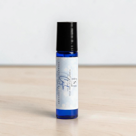 Simply Scentamental Calm aromatherapy rollerball in a blue glass bottle with a black cap on a white background.