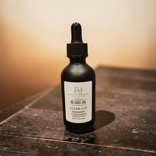 Simply Scentamental Clean Cut beard oil in a matte black glass dropper bottle on a rustic wooden surface.