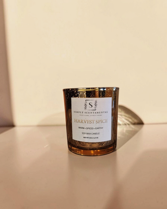 Simply Scentamental Harvest Spice soy wax candle in a reflective amber glass jar with a minimalist white label.