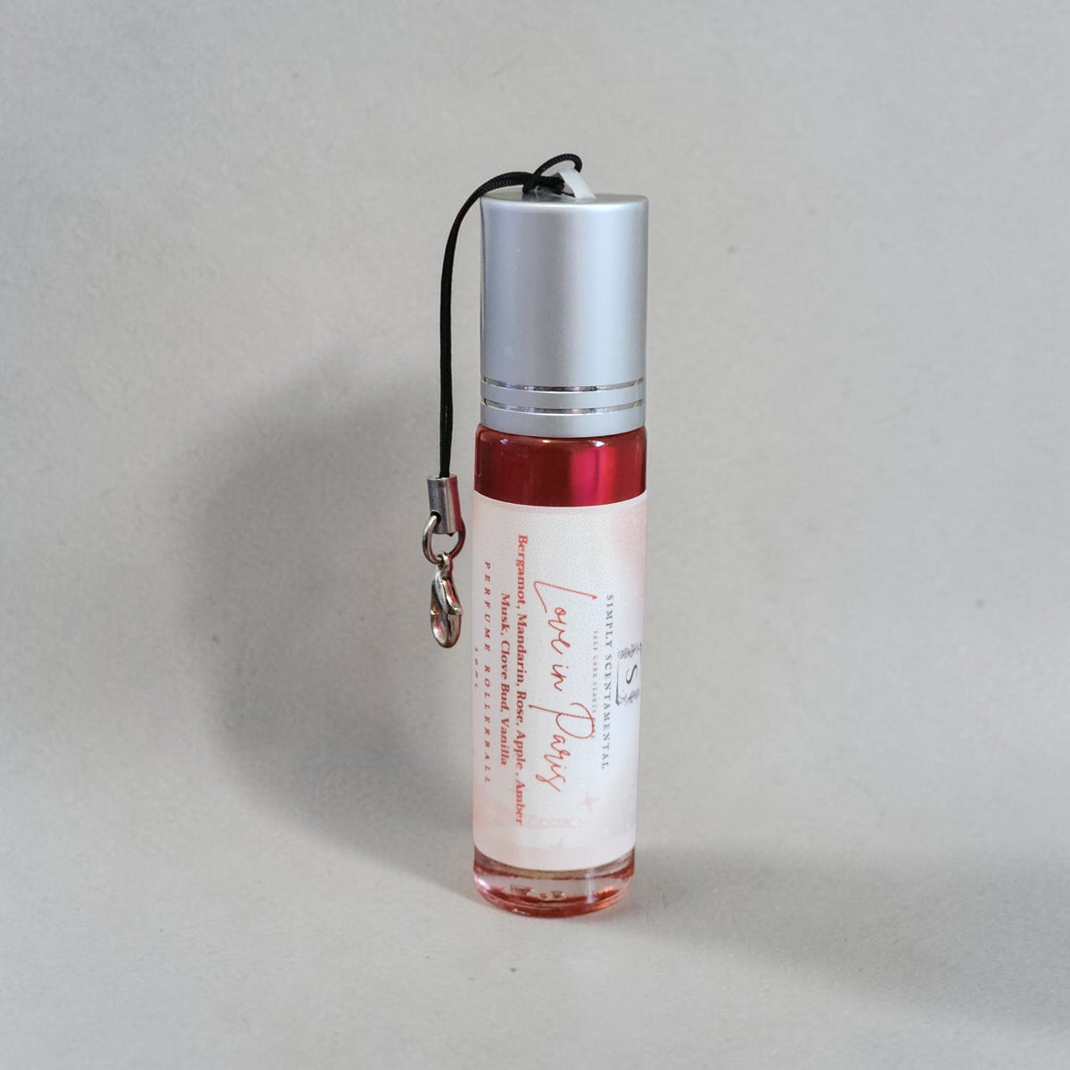 Simply Scentamental Love in Paris perfume oil in a 10ml glass rollerball bottle with a silver cap and black lanyard