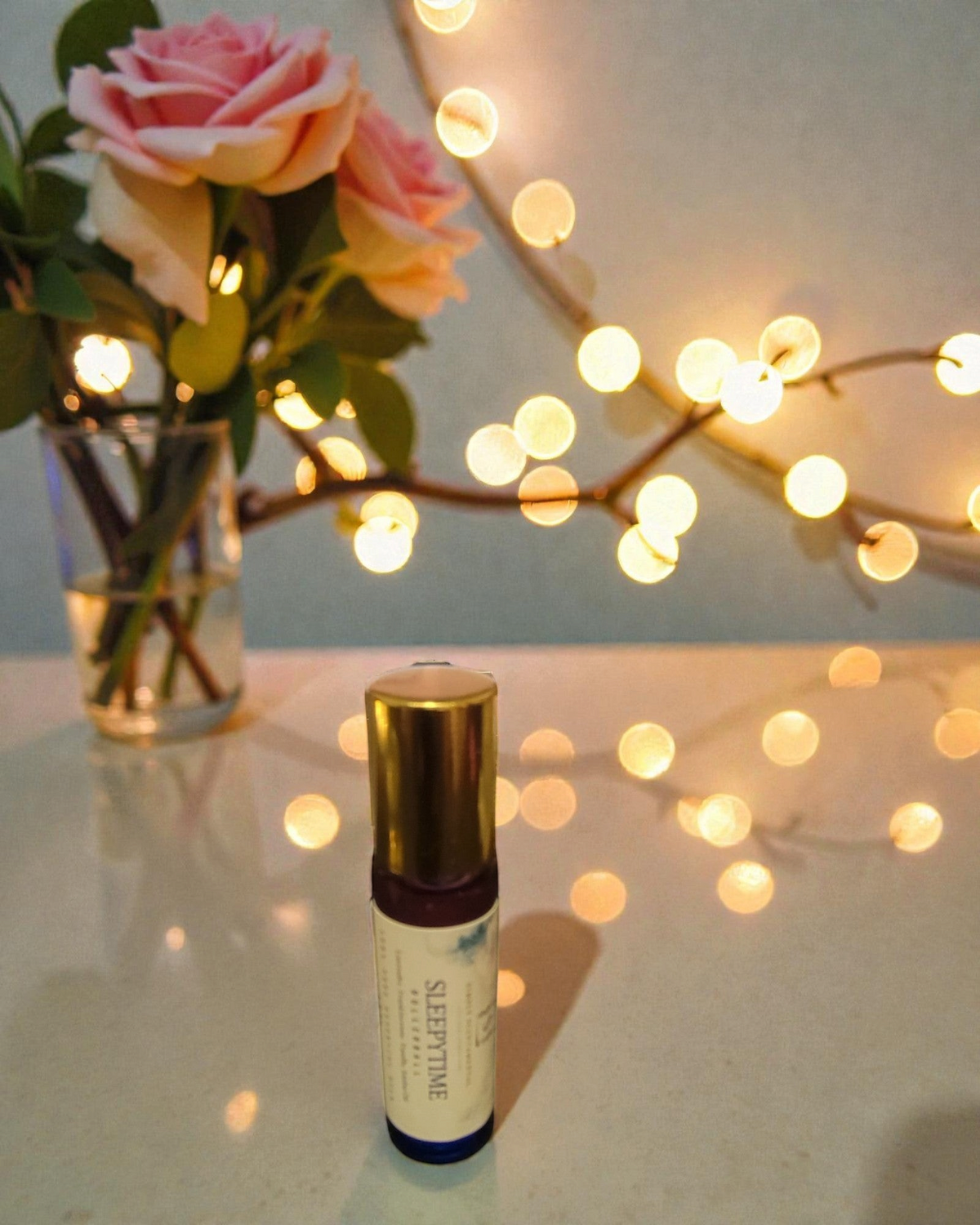 Simply Scentamental Sleepytime aromatherapy rollerball with lavender, frankincense, and vanilla on a reflective surface